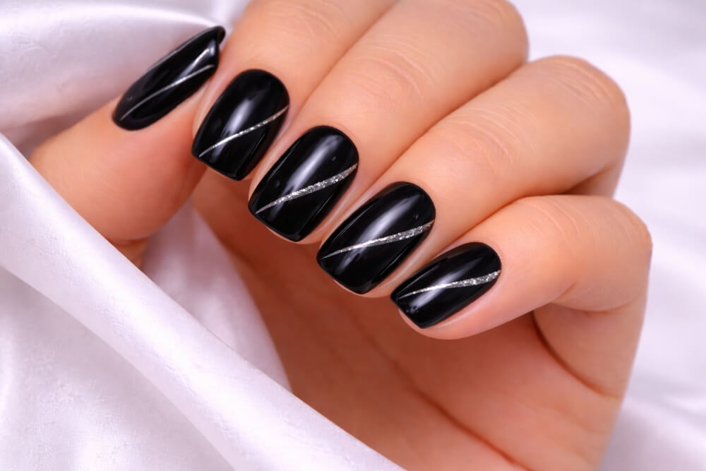 paznokcie pomalowane na czarno ze srebrnym wzorem 